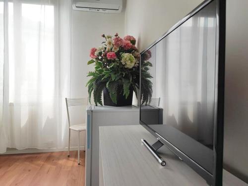 a living room with a television and a potted plant at [RHO FIERA] Apartment near the Metro in Pero