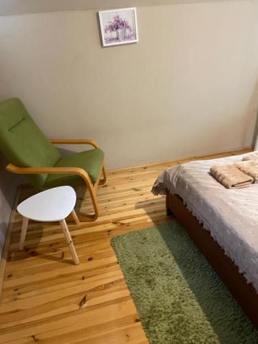 ein Schlafzimmer mit einem Bett, einem Stuhl und einem Teppich in der Unterkunft Domek Letniskowy Zacisze Guciów in Guciów