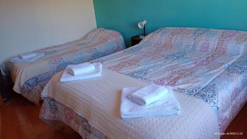 ein Schlafzimmer mit zwei Betten, auf denen Handtücher liegen in der Unterkunft LIBERATA in Esquel