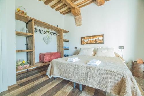 una camera con un letto in una stanza con pavimenti in legno di Ca' Gulino - Urbino - Villa con Minipiscina in Borgo Antico a Urbino