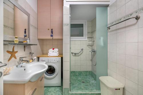 a bathroom with a sink and a washing machine at Maria’s Mansion 3 m from the SEA in Marathón