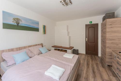a bedroom with a large bed and a wooden floor at Al Rabló Vendégház in Mátrakeresztes