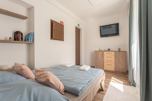 a bedroom with a bed and a television in it at Al Rabló Vendégház 