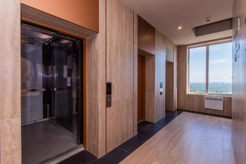 pasillo con puerta de cristal y ventana grande en MYFREEDOM Видові Апартаменти ВДНГ, en Kiev