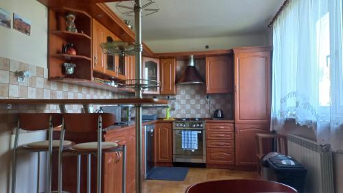 a kitchen with wooden cabinets and a stove top oven at Apartamenty Warka in Warka