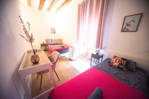a bedroom with two beds and a table with a red rug at Born Rooms - St Caterina in Barcelona