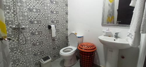 a small bathroom with a toilet and a sink at Séjour Paisible au Bord de la Nature. in Tangier