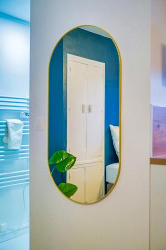 un miroir accroché au mur dans une pièce dans l'établissement Sweet Champagne - Centre-ville, à Épernay