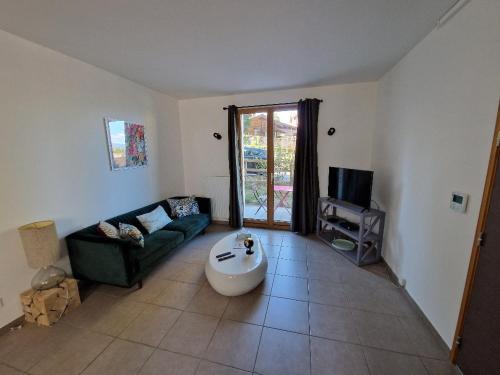 a living room with a couch and a tv at Les Mouettes in Thonon-les-Bains