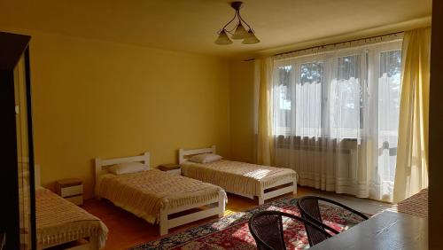 a room with two beds and a window at Apartamenty Warka in Warka