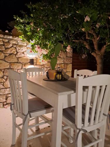una mesa blanca y sillas con una planta en Cottage Leonidas, 