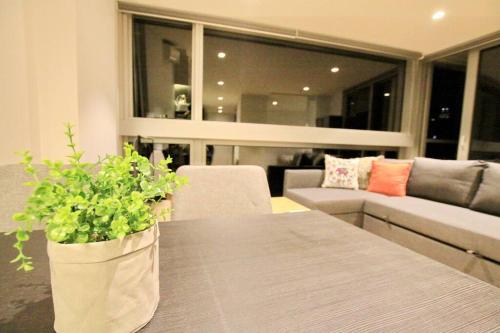 a living room with a table and a couch at Nest Apartments on Rose Lane in Melbourne