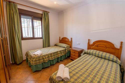 een hotelkamer met 2 bedden en een raam bij Novobarrosa Apartamentos Turísticos in Chiclana de la Frontera