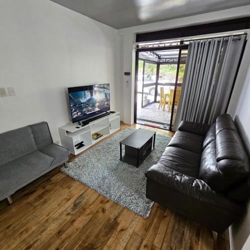 ein Wohnzimmer mit einem Sofa und einem Flachbild-TV in der Unterkunft A's Place - Casaroro in Valencia
