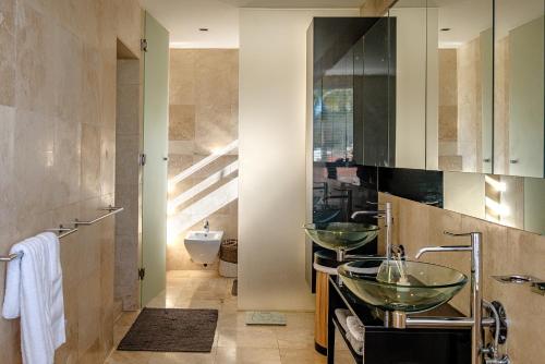 a bathroom with two vessel sinks and a toilet at Villa Legacy in Cape Town