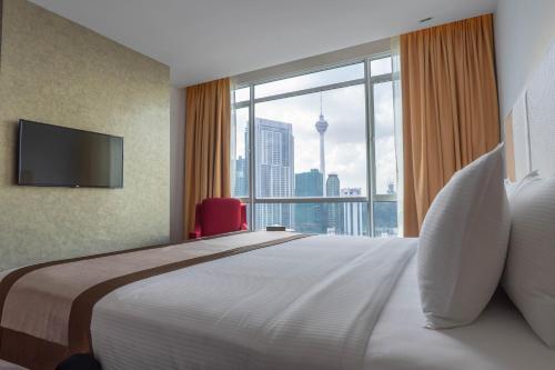 a bedroom with a large bed with a large window at Tamu Hotel & Suites Kuala Lumpur in Kuala Lumpur