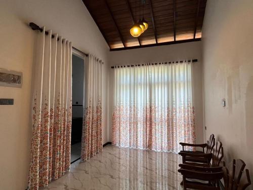 uma sala de estar com uma grande janela com cortinas em Villa Tropical Oasis em Balapitiya