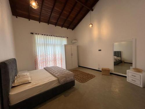 um quarto com uma cama e uma grande janela em Villa Tropical Oasis em Balapitiya