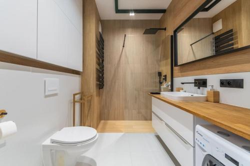 a bathroom with a toilet and a sink at Portova Relax by Grand Apartments in Gdynia