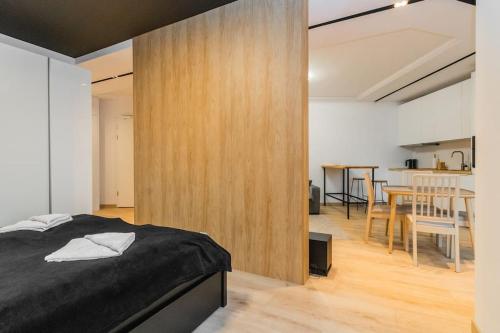 1 dormitorio con 1 cama y pared de madera en Portova Relax by Grand Apartments, en Gdynia
