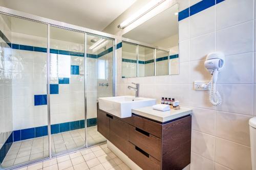 a bathroom with a sink and a shower at Il Mondo Boutique Hotel in Brisbane