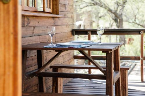 una mesa de madera con 2 copas de vino en un porche en Stone cottage in Haarties, en Kalkheuvel