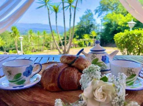 una mesa con tazas de té y una barra de pan en La Cascina Scalera per il tuo relax con piscina sauna ed Idromassaggio, en Castel Campagnano