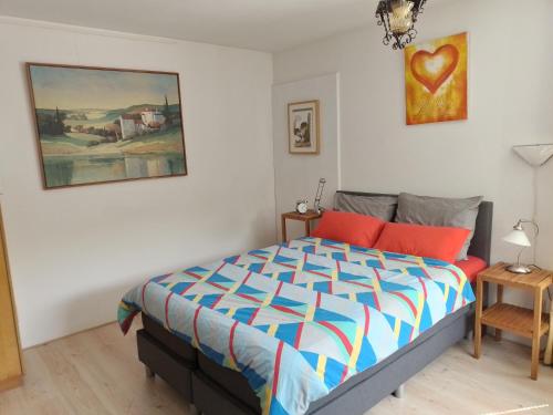 ハーレンにあるDrenthse-Groninger landschapのベッドルーム1室(ベッド1台付)が備わります。壁には絵画が飾られています。