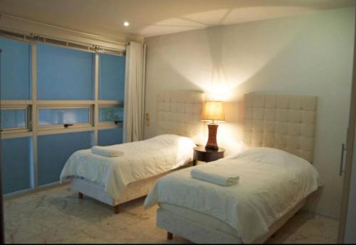 une chambre avec deux lits et une lampe sur une table dans l'établissement 3 BR, Ocean View, Gym/Parking, à Playa del Carmen