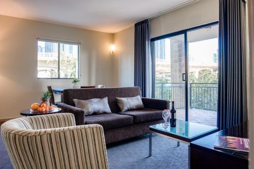 a living room with a couch and a table at Il Mondo Boutique Hotel in Brisbane