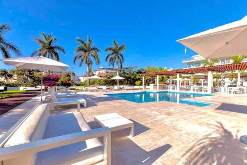 une piscine avec chaises et parasols dans un complexe hôtelier dans l'établissement 3 BR, Ocean View, Gym/Parking, à Playa del Carmen