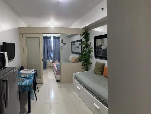 Cette petite chambre comprend un lit et un salon. dans l'établissement 1BR Condotel - MOA View, à Manille