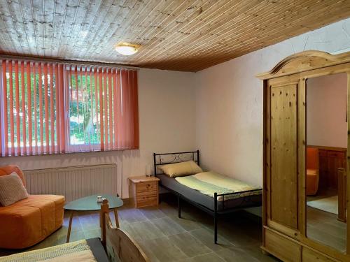 a room with a bed and a couch and windows at Gödelsteinhof in Contwig