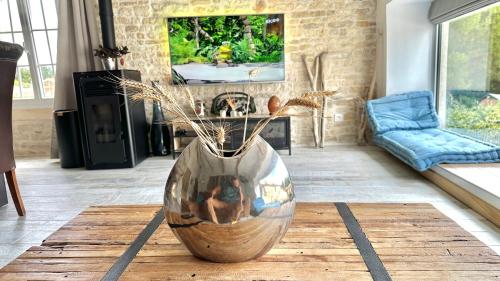 a large vase sitting on a table in a living room at Le Grenier - Gîte de Charme La Rochelle in Saint-Médard-dʼAunis