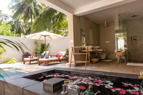 a child playing with flowers in a pool in a house at Neeleshwar Hermitage in Nīleshwar