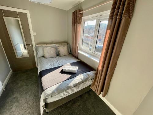a small bed in a room with a window at Silver Stag Properties, 3 BR House in Ashby in Ashby de la Zouch