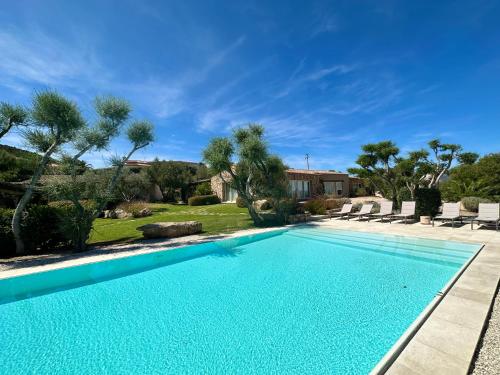 - une piscine en face d'une maison arborée dans l'établissement Pedra Smeralda, à Golfo Aranci