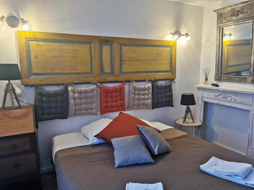 Un dormitorio con una cama con almohadas de colores. en Les Tamaris, en Campsegret