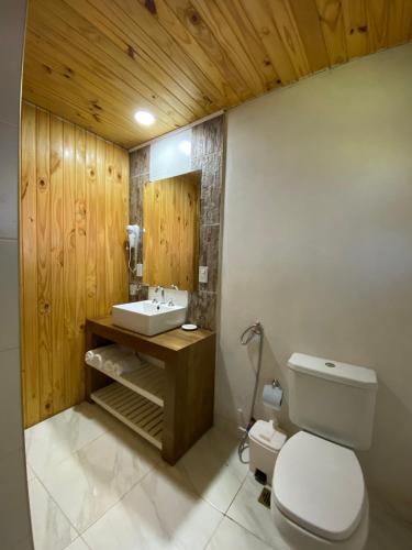 a bathroom with a white toilet and a sink at Complejo Paranay in Puerto Paranay