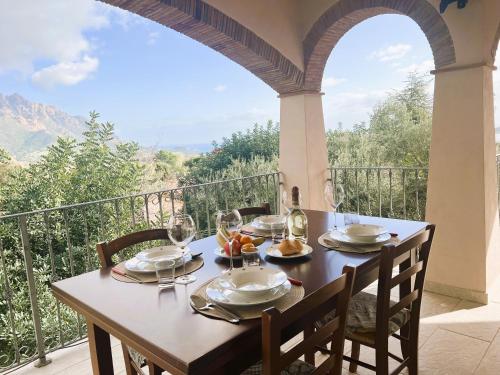 a table with wine glasses and food on a balcony at Casa vacanze Sardegna B in Tertenìa