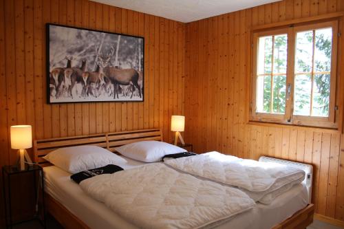 1 dormitorio con 1 cama y una foto de ciervo en Chalet Antoine 5p en Moleson