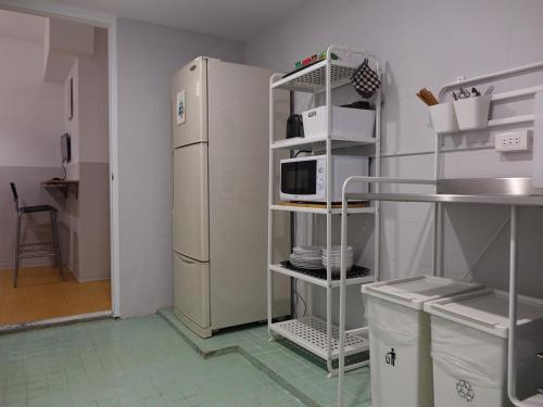 a kitchen with a white refrigerator and a shelf at Fun Taipei Share House 樂趣台北共居 - 月租 in Taipei