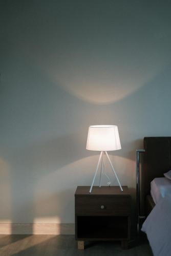 eine Lampe auf einem Nachttisch neben einem Bett in der Unterkunft Tropical Bliss Villa by The Feelas in Bandung