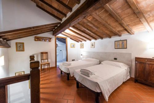 2 bedden in een kamer met houten plafonds bij San Frediano House in Florence
