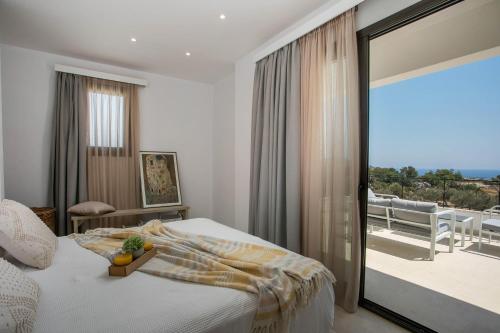 um quarto com uma cama e vista para uma varanda em Emarmene Sea View & Mountain Hideaway near Faliraki and Airport em Afantou