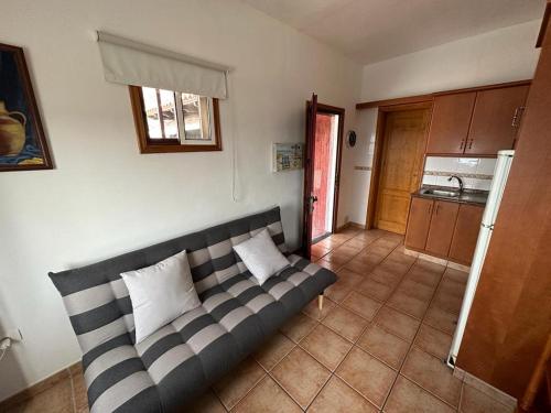 a couch in a living room with a kitchen at Casa Jesus in Fuencaliente de la Palma