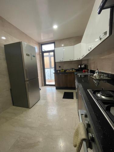 Luxury Apartment in Agadir Bay في أغادير: مطبخ مع ثلاجة ستانلس استيل ونافذة