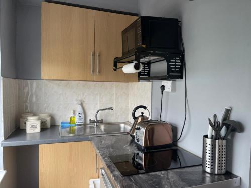 a kitchen with a sink and a toaster on a counter at Small Double Studio close to King's Cross & Camden in London