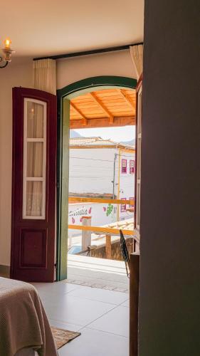 an open door to a bedroom with a view of the ocean at Pouso da Rita - Tiradentes in Tiradentes