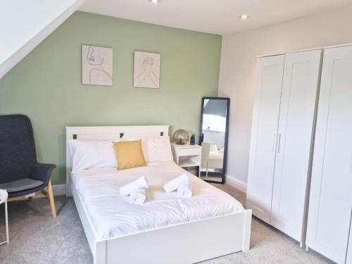 1 dormitorio con 1 cama blanca grande y 1 silla en Hyland Apartment by CityNest, en Chelmsford